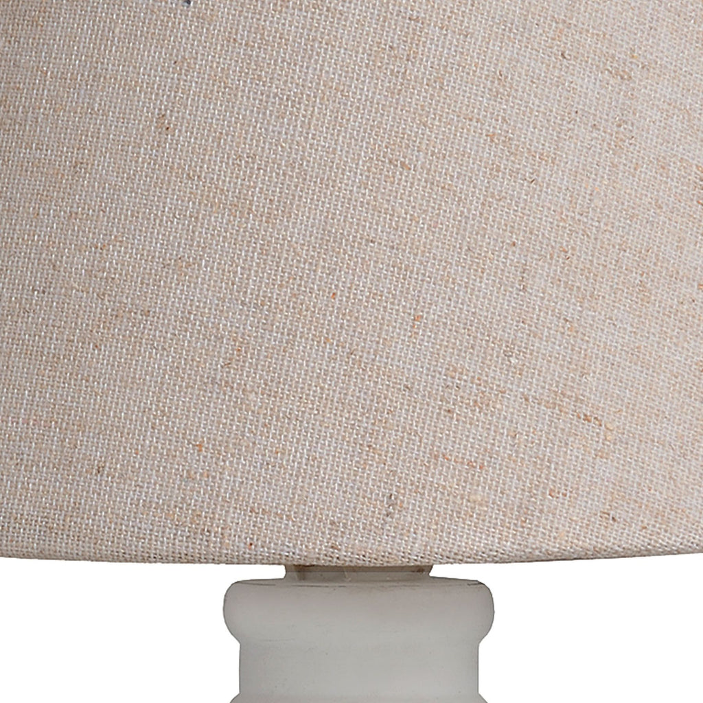 Close-up of a beige lampshade with a white base.