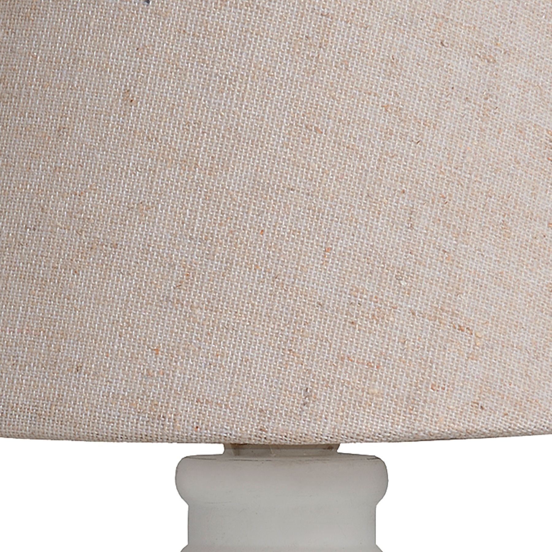 Close-up of a beige lampshade with a white base.