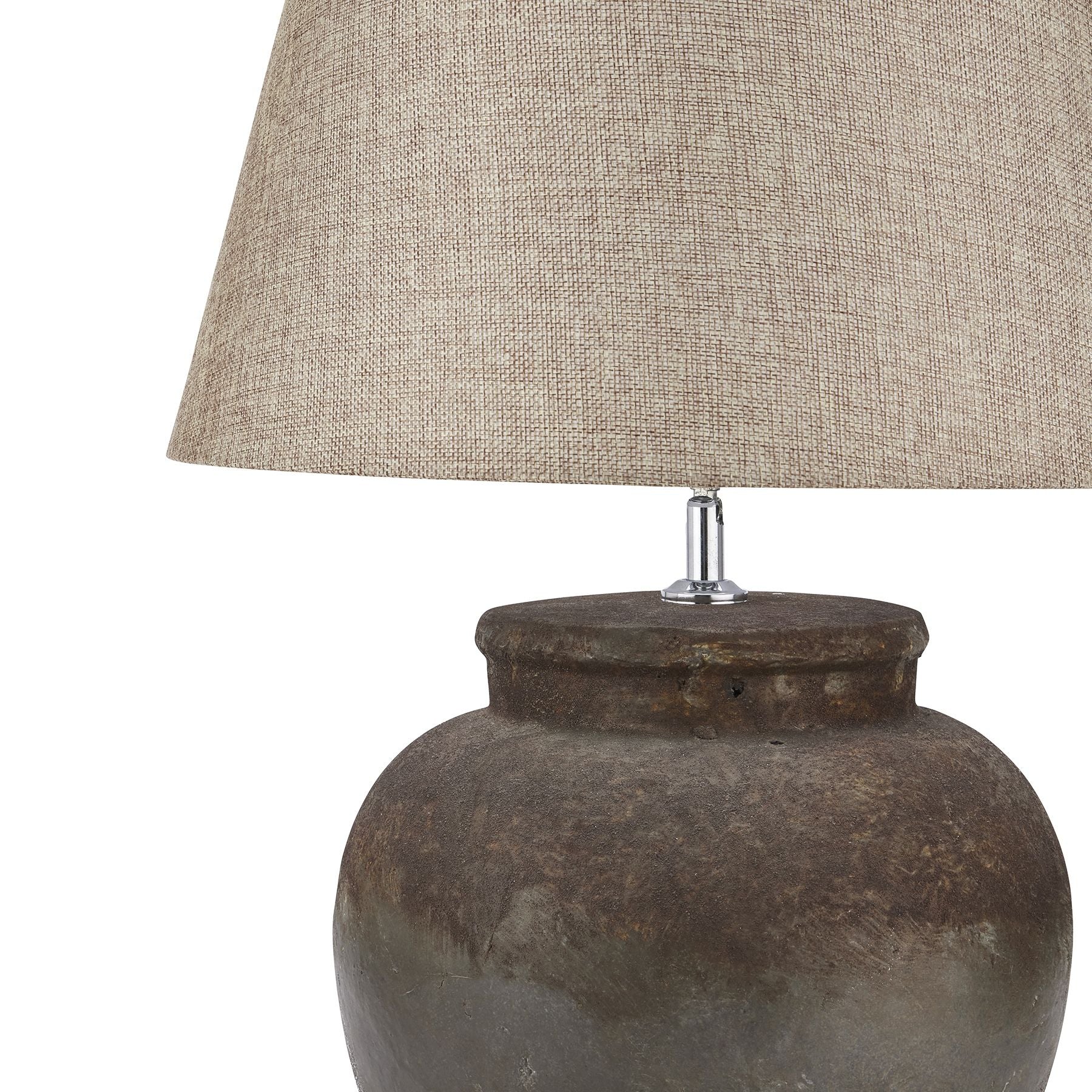 Table lamp with textured brown base and beige fabric shade on a white background