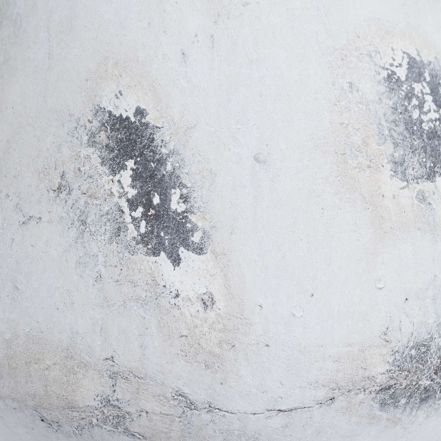 Close-up of a textured white surface with black smudges