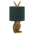 Decorative table lamp with gold rabbit body and green lampshade on a white background