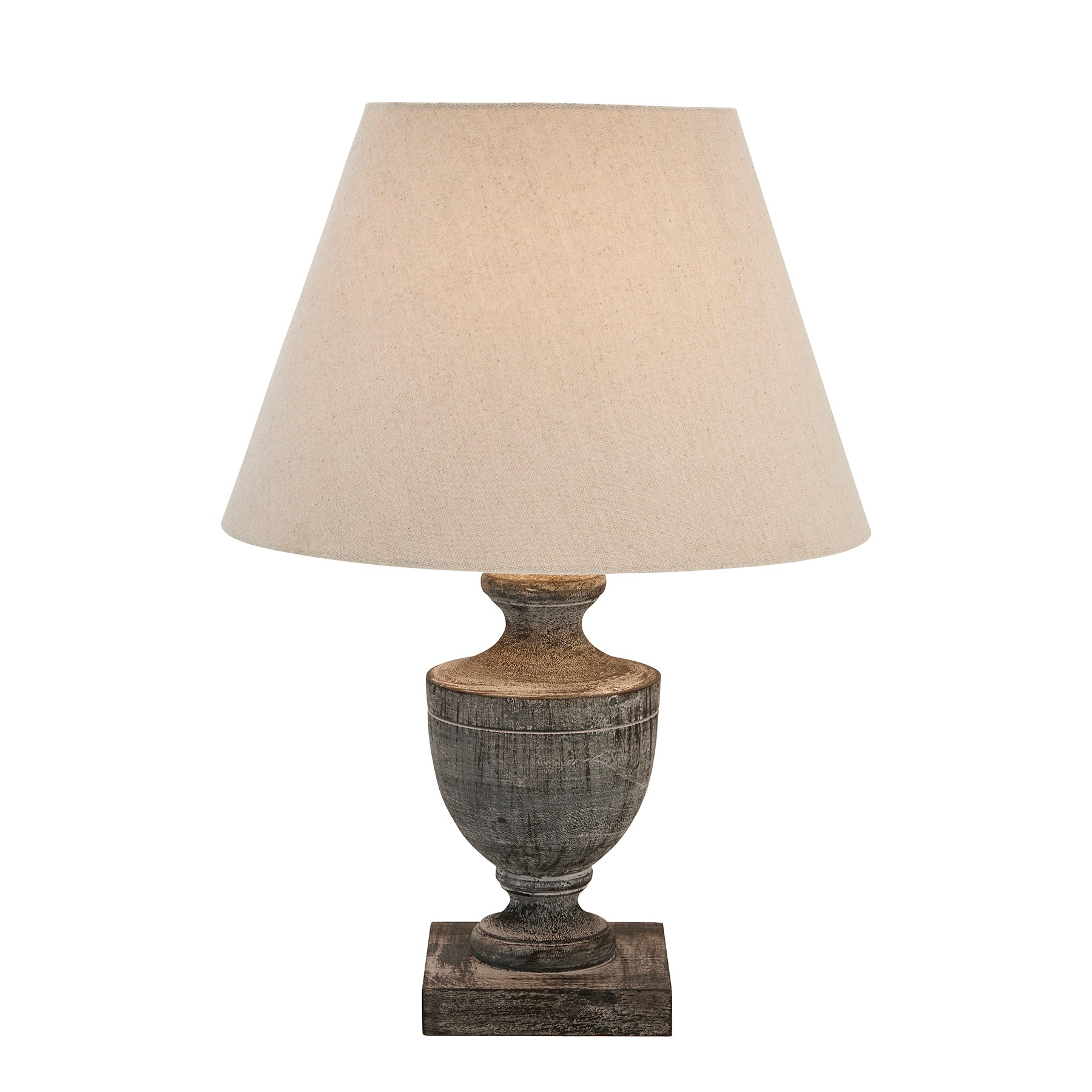 Table lamp with a textured base and beige lampshade on a white background