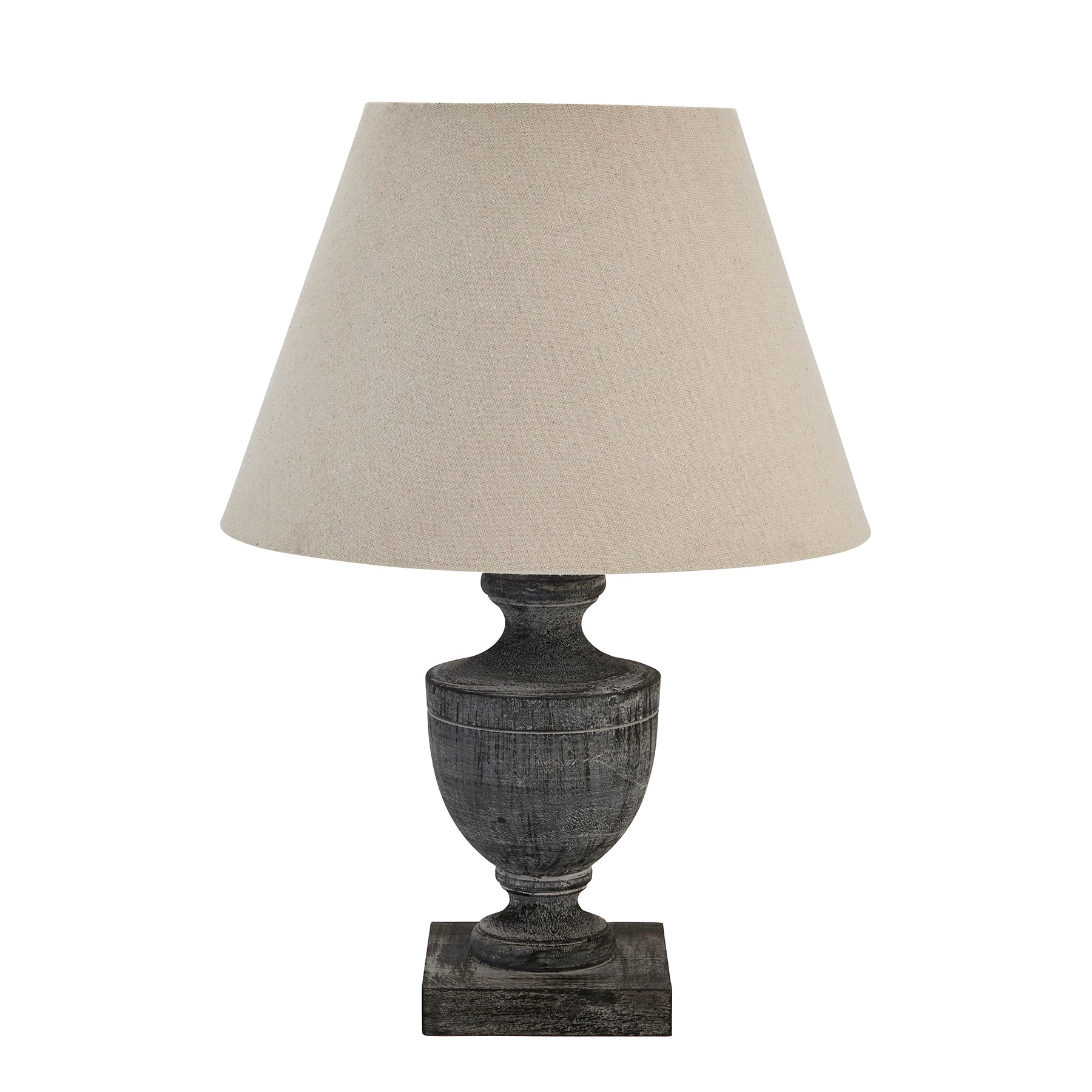Table lamp with a textured base and beige lampshade on a white background