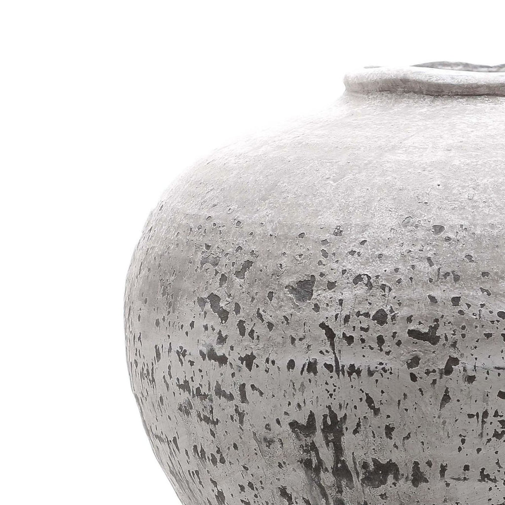 Close-up of a textured gray ceramic jar on a white background