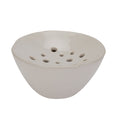 White ceramic bowl with holes on a white background