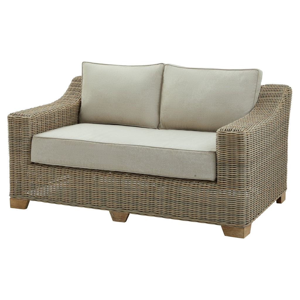 Wicker loveseat with beige cushions on a white background