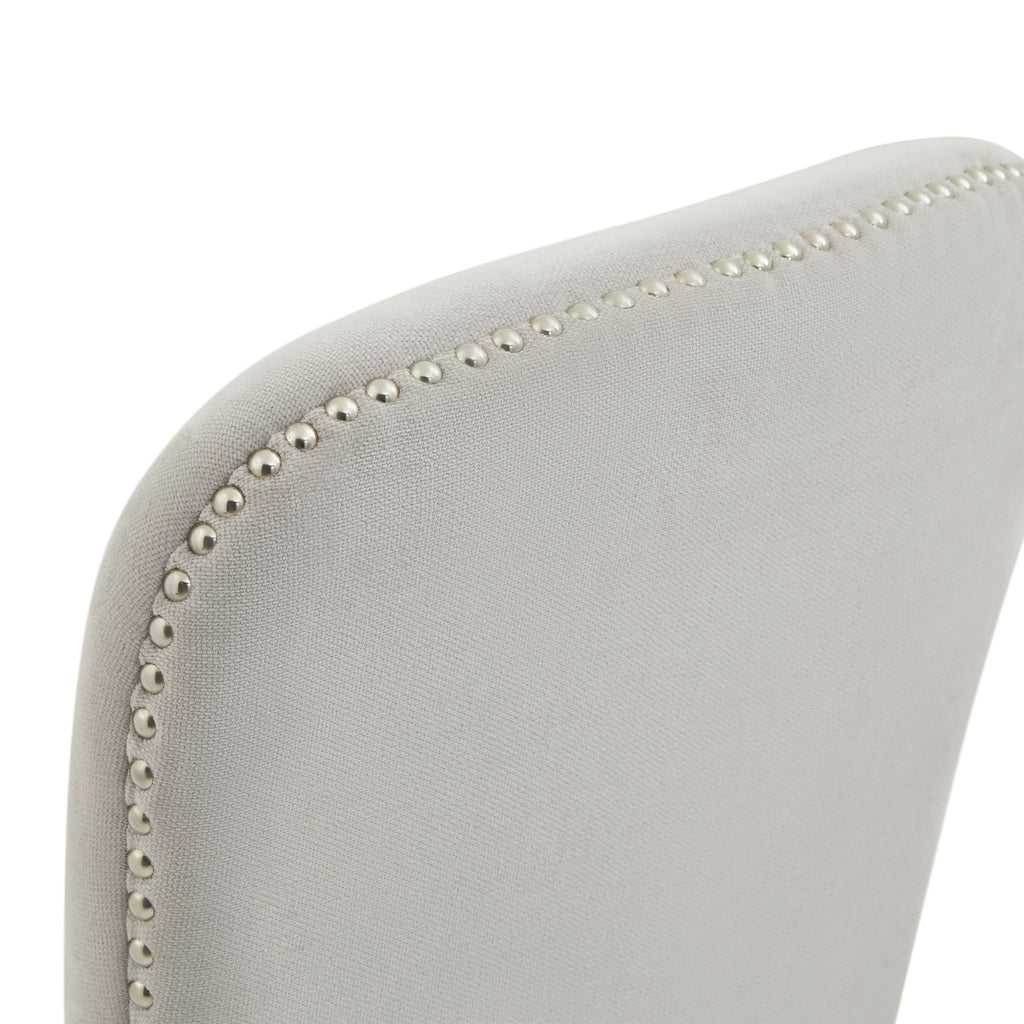 Gray upholstered chair with decorative nailhead trim on a white background