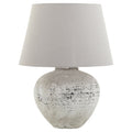 Table lamp with textured gray base and white shade on a white background