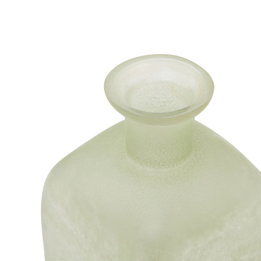 Light green glass bottle with a textured surface on a white background