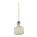 Green candle holder with a white candle on a white background