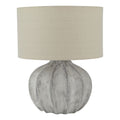 Table lamp with textured gray base and beige lampshade on a white background