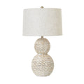Table lamp with textured base and white shade on a white background