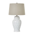 Table lamp with white textured base and beige lampshade on a white background