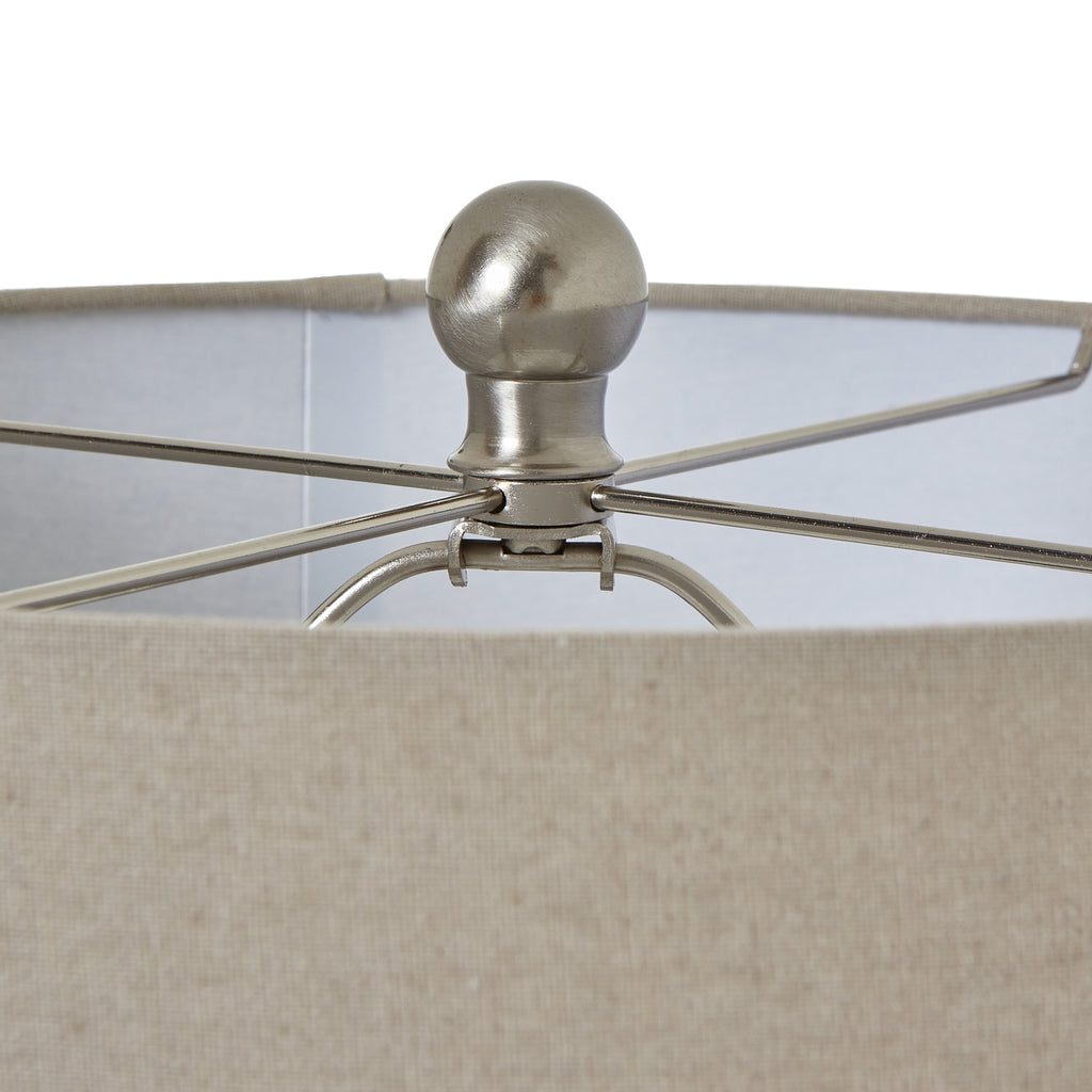 Close-up of a lamp with a metallic fixture and beige fabric shade.