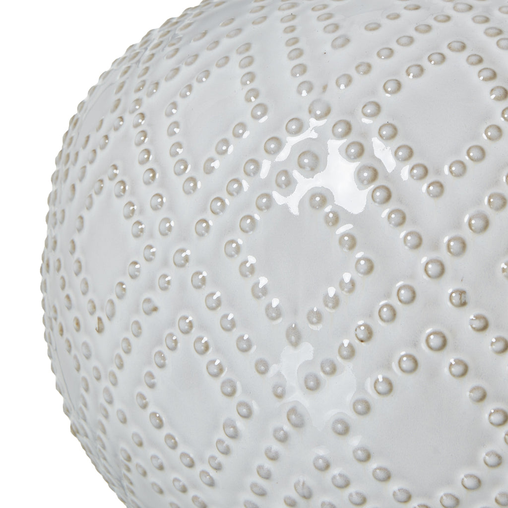 Close-up of a white spherical object with a textured surface on a white background