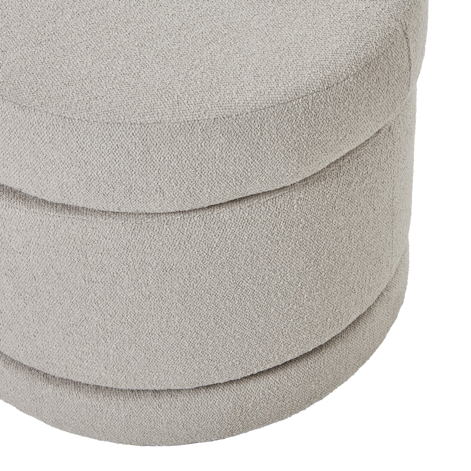 Close-up of a textured gray ottoman with stacked cushions on a white background