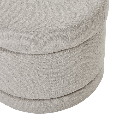 Close-up of a textured gray ottoman with stacked cushions on a white background