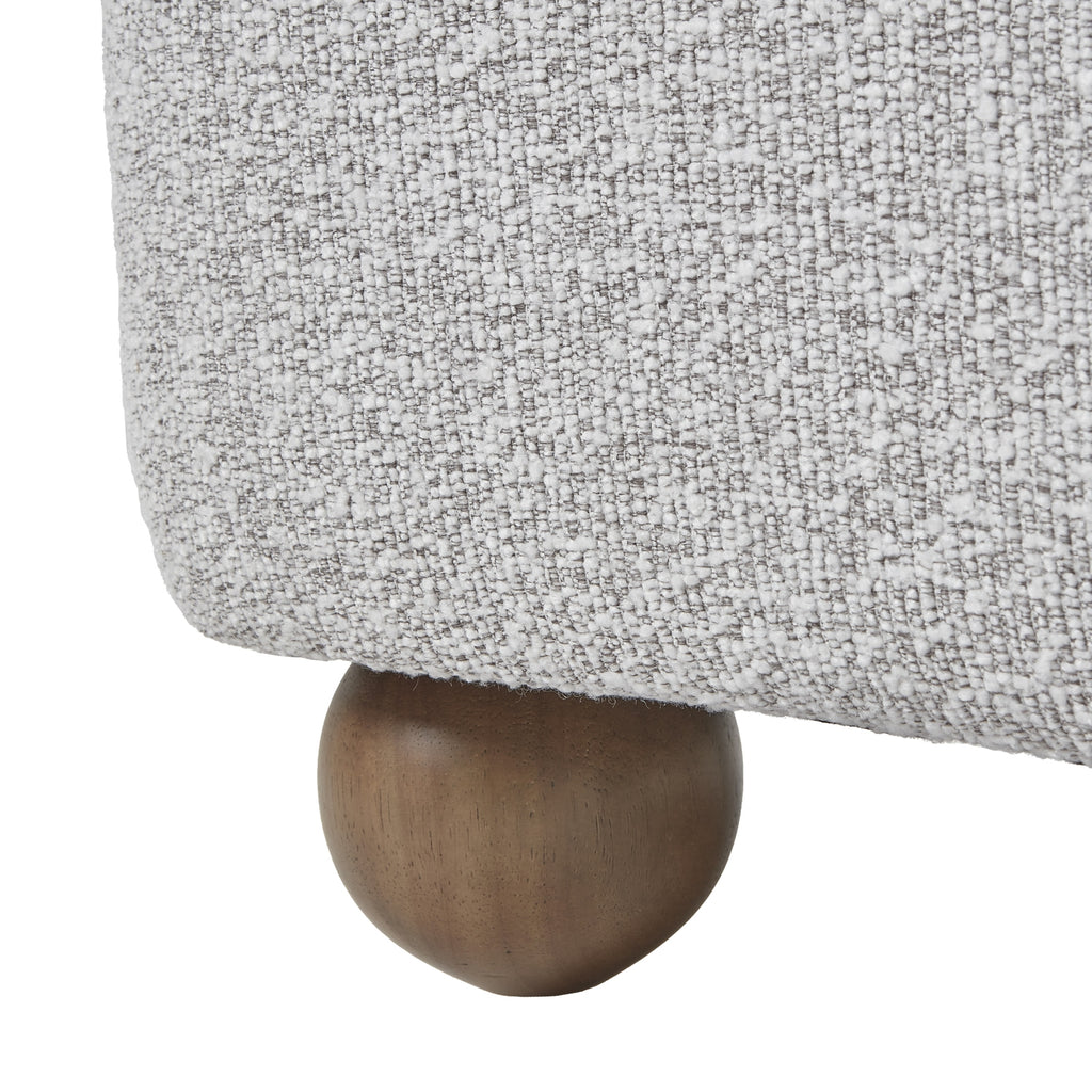 Close-up of a textured gray fabric surface with a wooden leg.