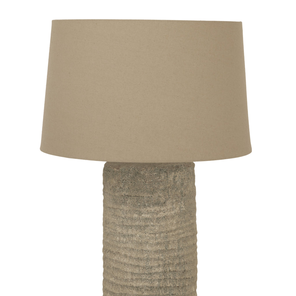 Beige textured table lamp with a matching shade on a white background