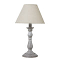 Table lamp with a textured white base and beige lampshade on a white background