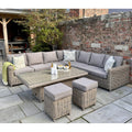 Outdoor patio set with sectional sofa, coffee table, and ottomans on a stone patio.