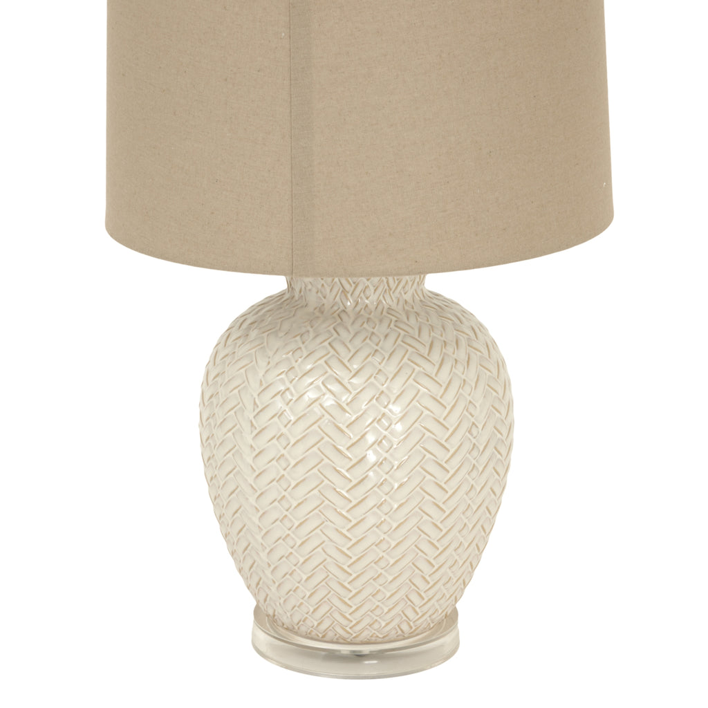 Decorative table lamp with woven design on a white background