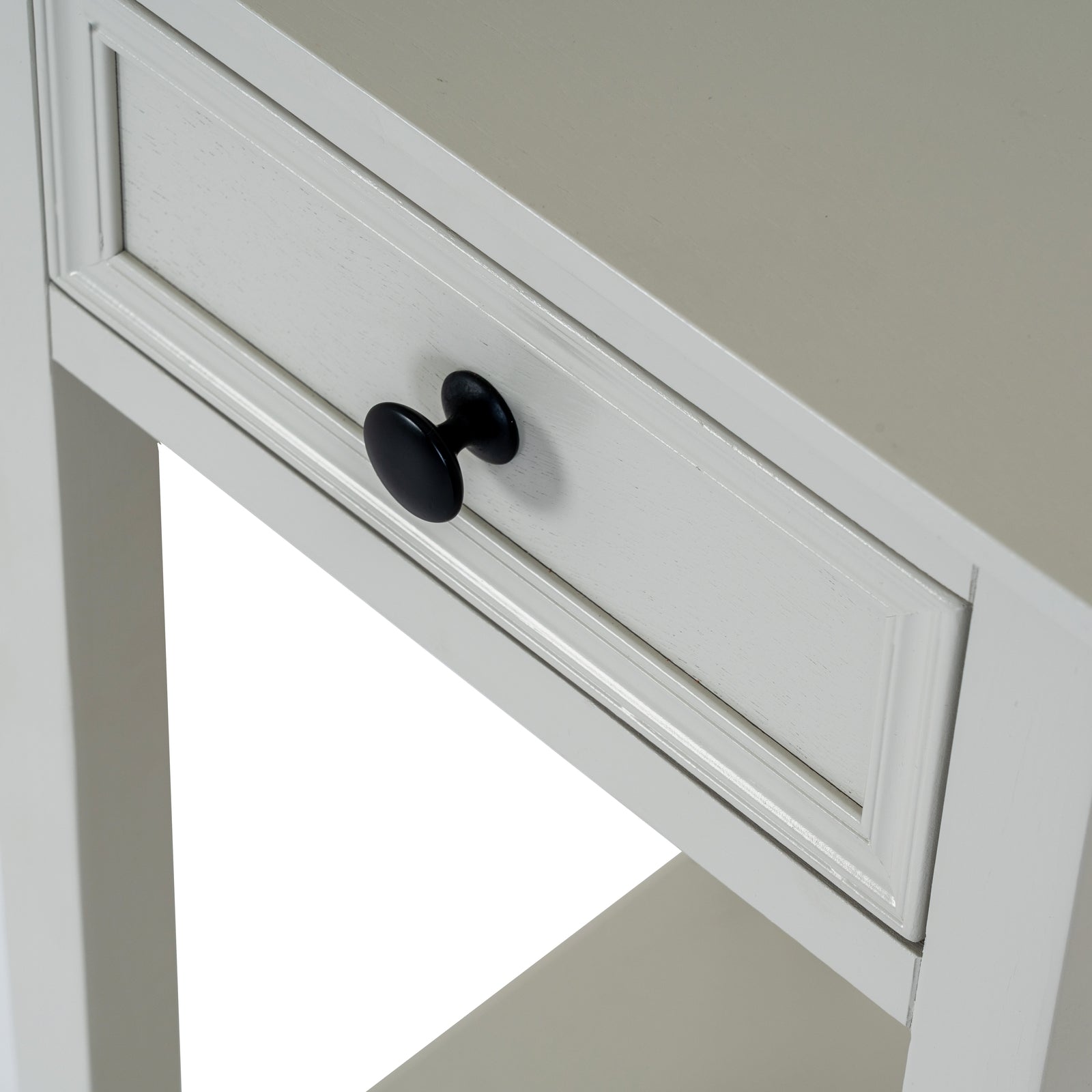 White cabinet with a black knob on a neutral background