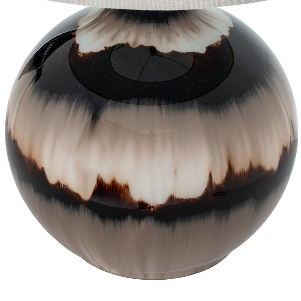 Round decorative object with black and white pattern on a white background