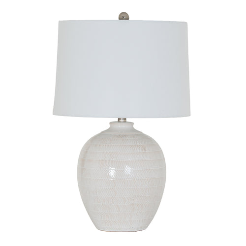 Table lamp with textured white base and white shade on a white background