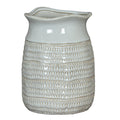 White ceramic pitcher with textured design on a white background