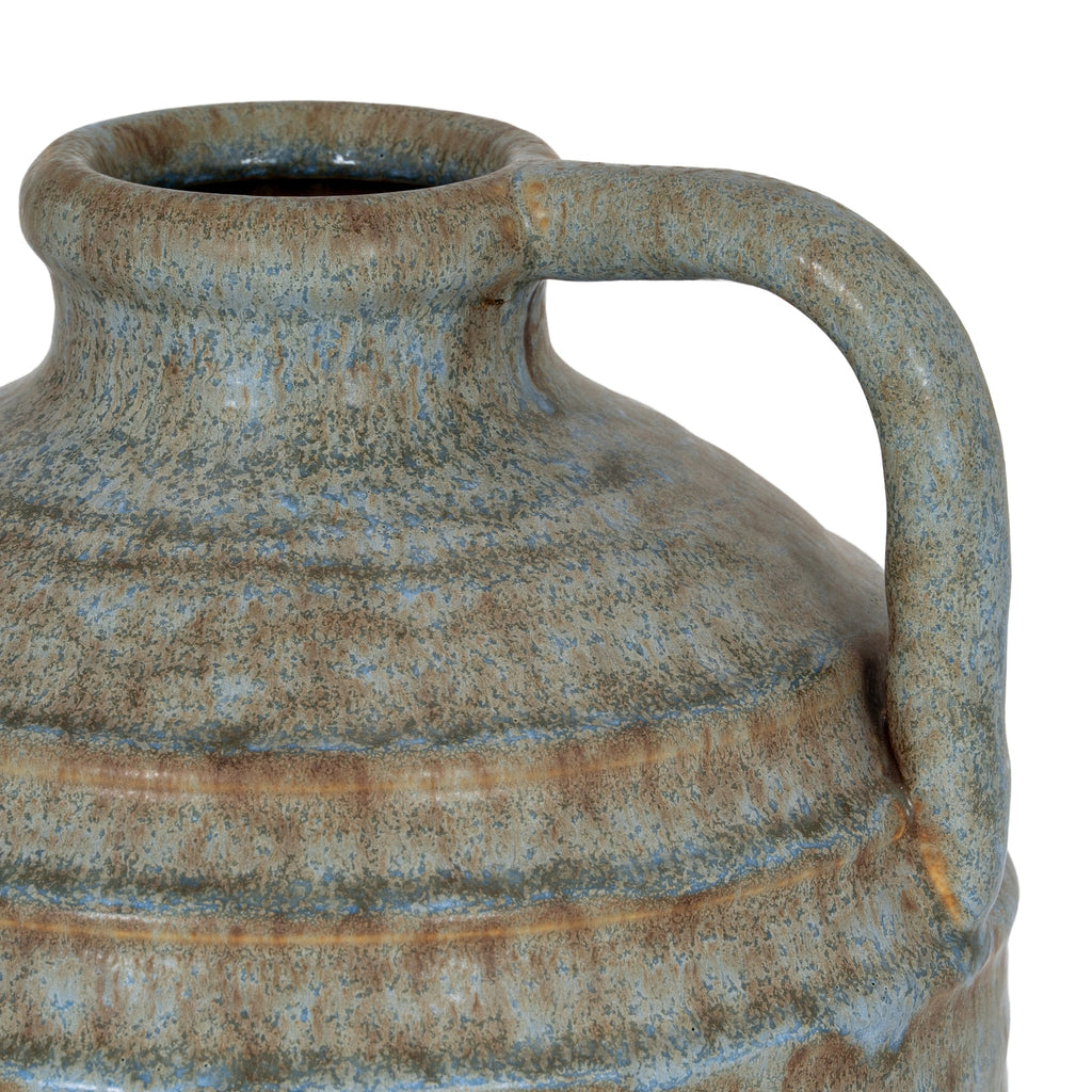 Close-up of a ceramic jar with a handle on a white background