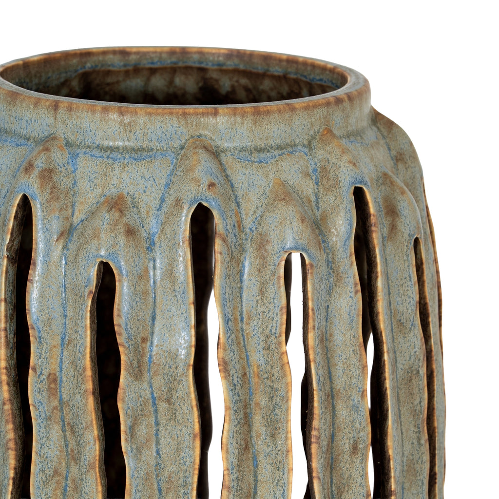 Ceramic vase with textured surface and cut-out design on a white background