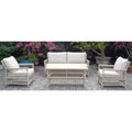 White wicker outdoor furniture set with cushions on a patio