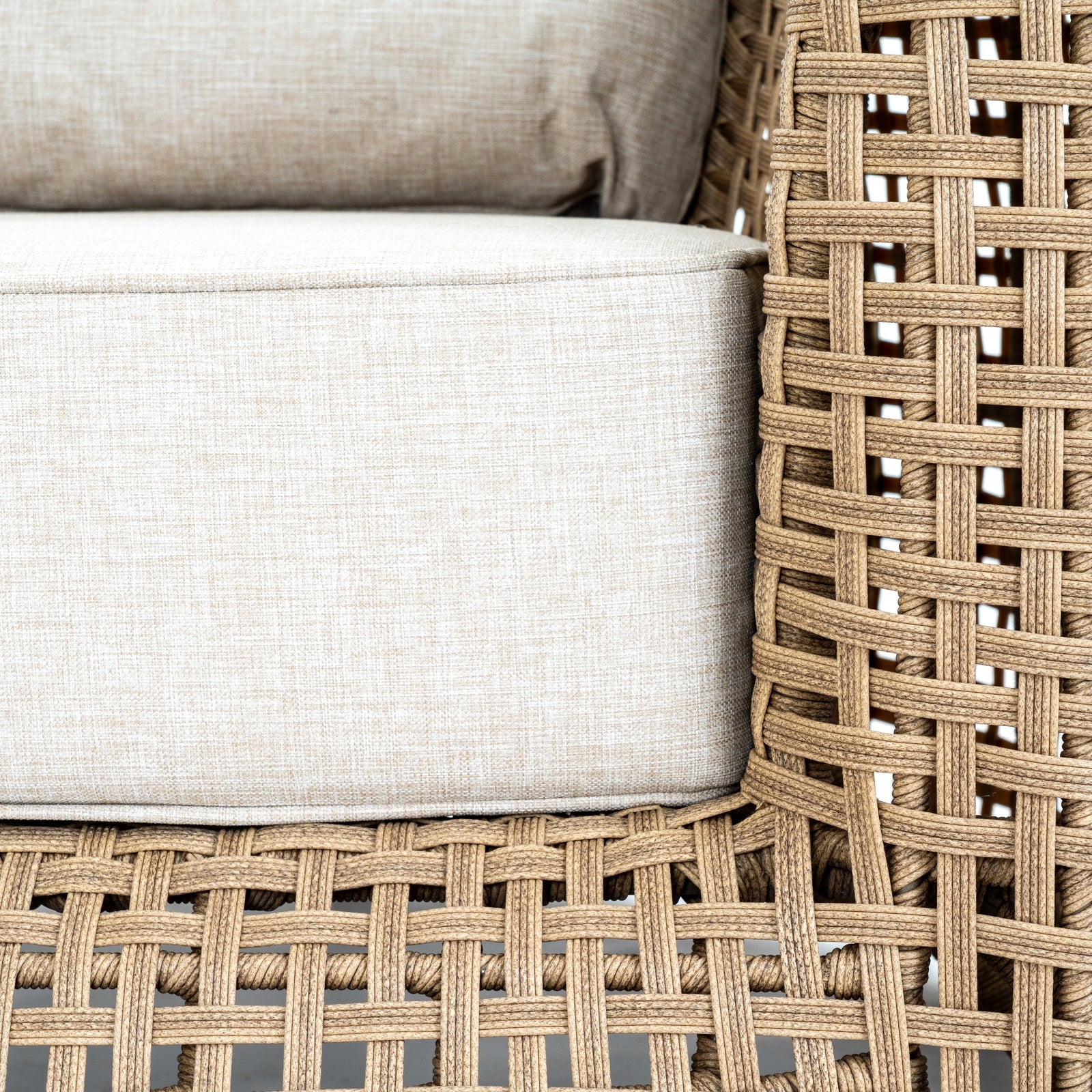 Close-up of woven chair with beige cushions