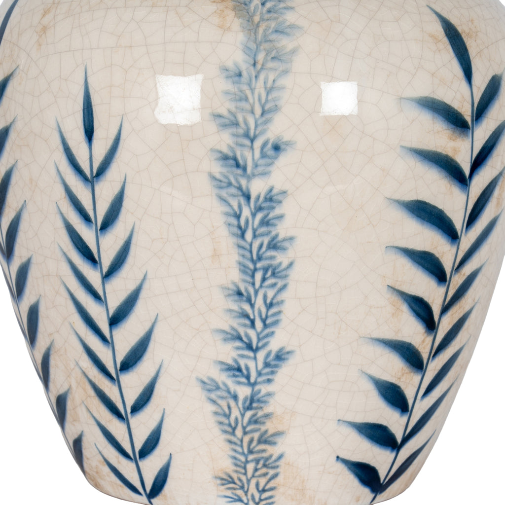 Ceramic vase with blue leaf patterns on a beige background